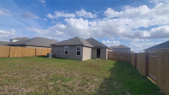 rear view of house featuring a lawn and central AC unit