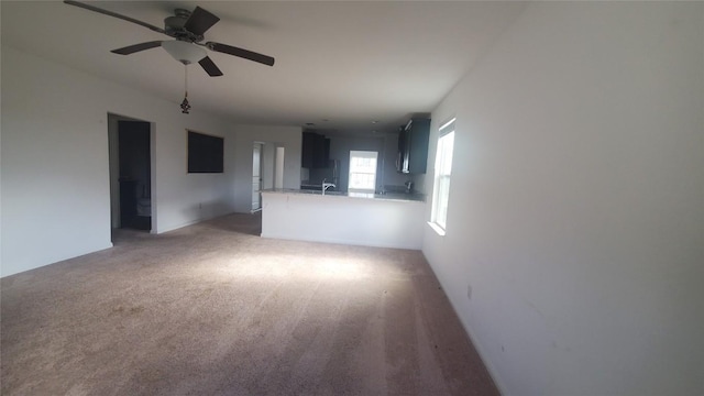 unfurnished living room with carpet flooring and ceiling fan