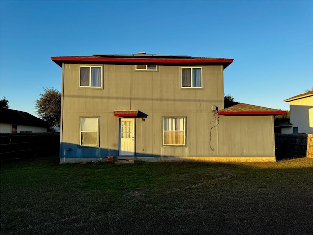 rear view of house featuring a lawn