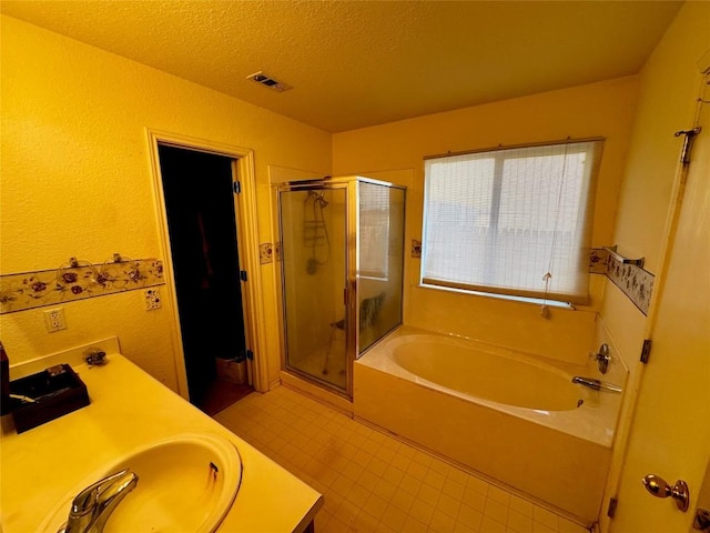 bathroom featuring vanity, separate shower and tub, and a textured ceiling