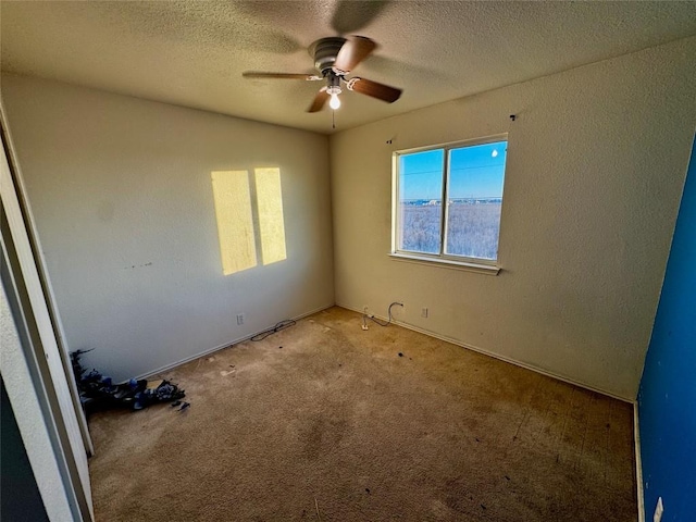 carpeted empty room featuring ceiling fan and a textured ceiling