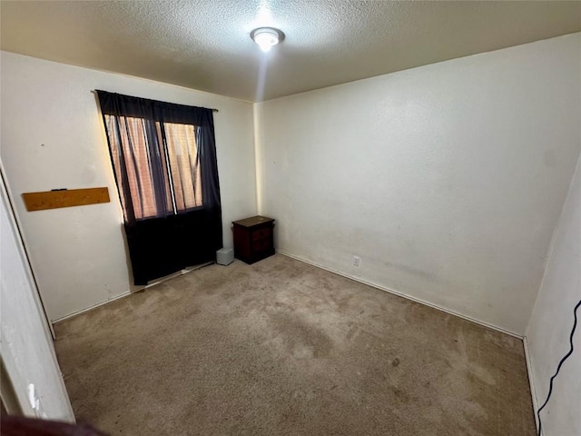 carpeted spare room with a textured ceiling