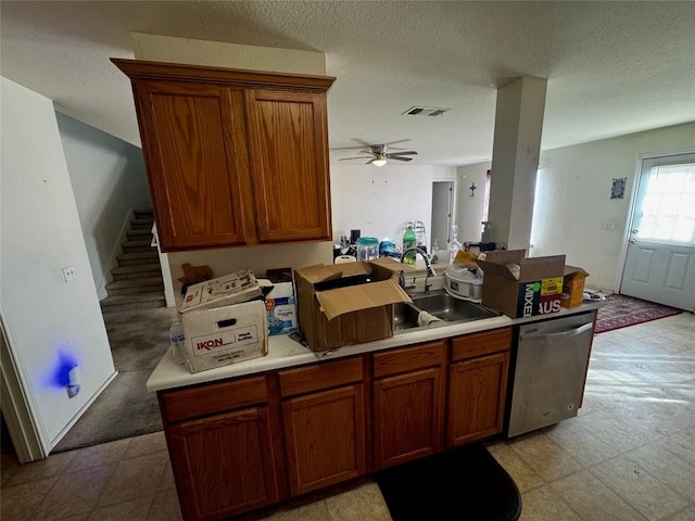 kitchen with a textured ceiling, dishwasher, ceiling fan, and sink