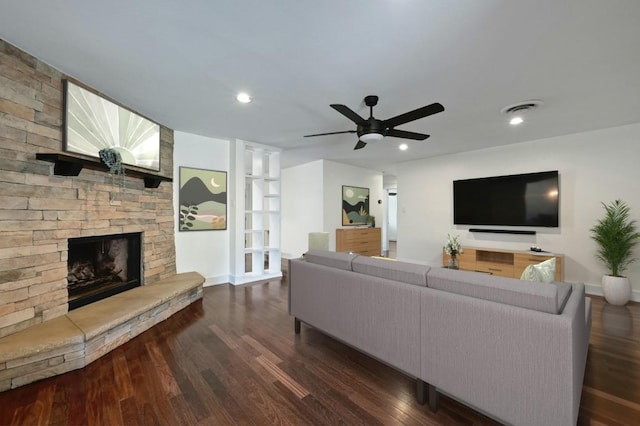 living area featuring recessed lighting, visible vents, a stone fireplace, and dark wood-style floors