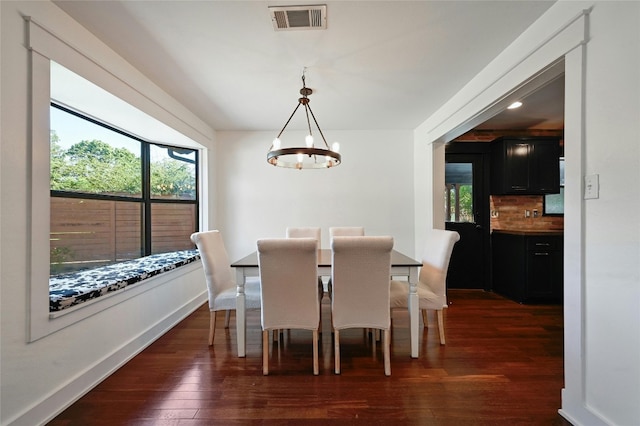 dining area with dark wood finished floors, baseboards, visible vents, and a chandelier