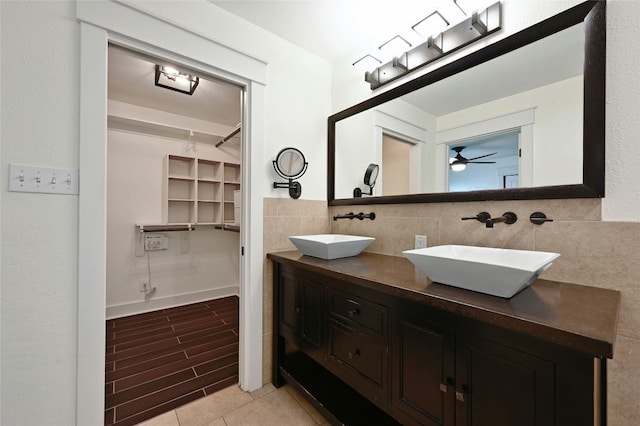 full bathroom featuring a sink, a walk in closet, wood finished floors, and double vanity