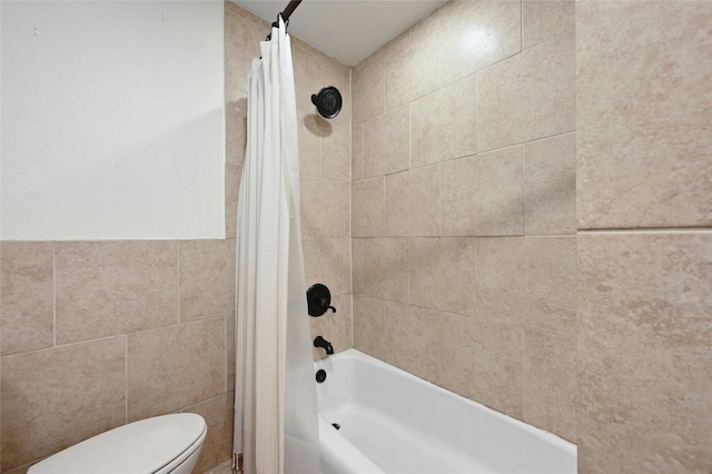 full bathroom featuring shower / bath combo with shower curtain, toilet, and tile walls