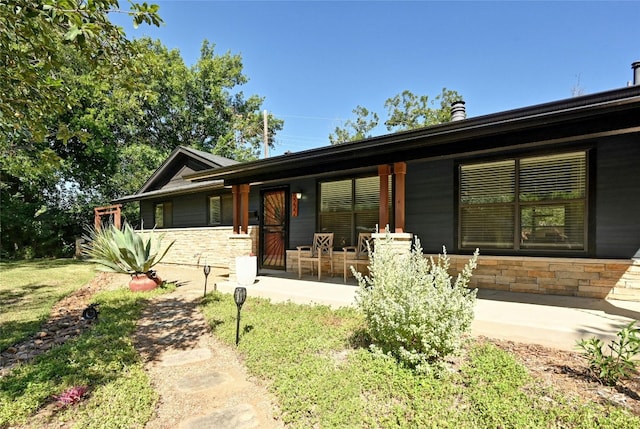 view of front facade with a porch and stone siding