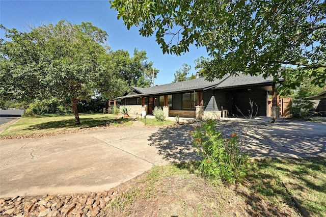 single story home featuring a front lawn, an attached garage, and driveway