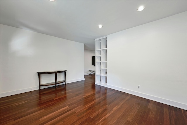 empty room with recessed lighting, wood finished floors, and baseboards