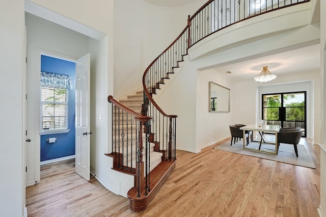 stairs featuring wood-type flooring and a chandelier