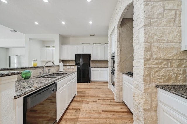 kitchen with black appliances, white cabinetry, sink, and dark stone counters