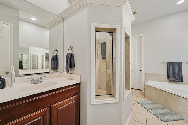 bathroom with tile patterned floors, vanity, and a relaxing tiled tub