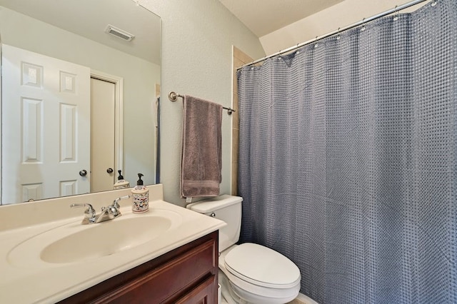 bathroom featuring vanity, vaulted ceiling, and toilet