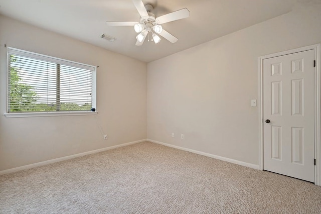 carpeted spare room featuring ceiling fan