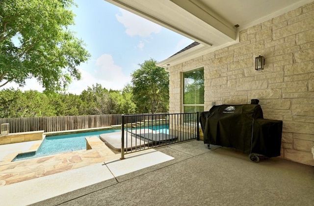 view of swimming pool with grilling area and a patio