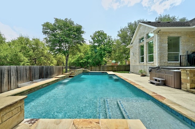 view of swimming pool with a hot tub