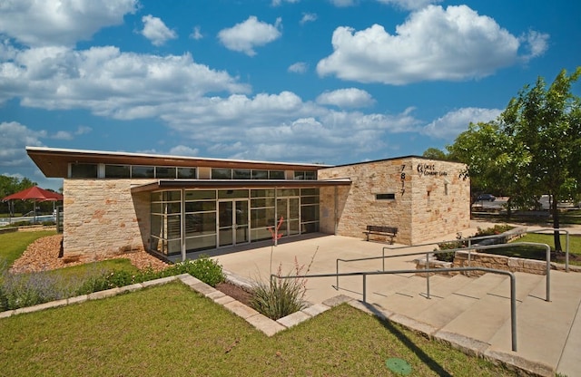 back of property with a patio area, a sunroom, and a yard