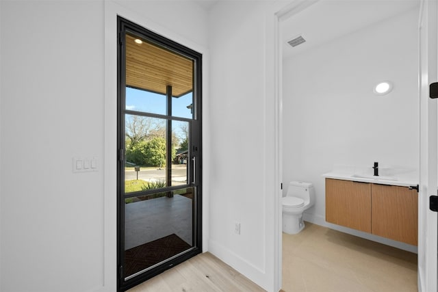 1407 Valleyridge Dr Unit A, Austin, TX 78704 - bathroom featuring visible vents, baseboards, toilet, wood finished floors, and vanity