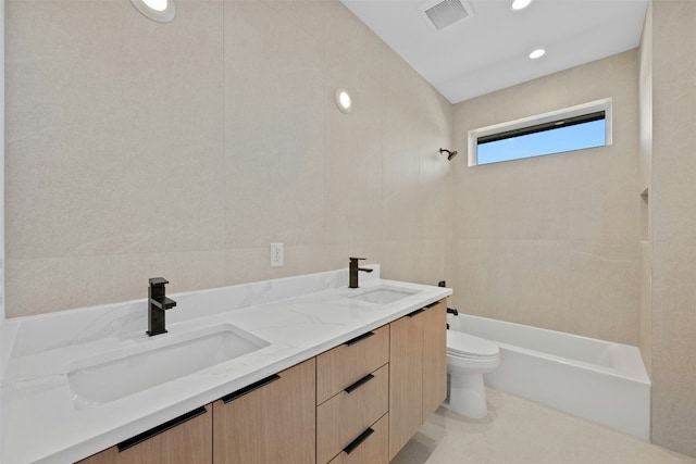 full bathroom featuring bathing tub / shower combination, vanity, tile walls, and toilet