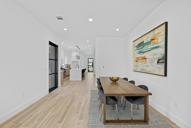 dining room with light hardwood / wood-style flooring and sink