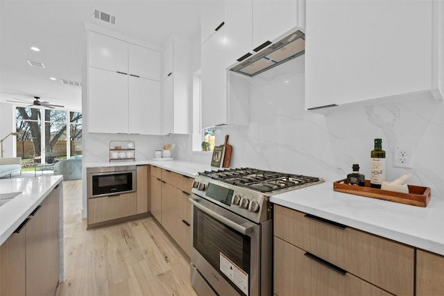 1407 Valleyridge Dr Unit A, Austin, TX 78704 - kitchen with light countertops, stainless steel range with gas cooktop, under cabinet range hood, and tasteful backsplash
