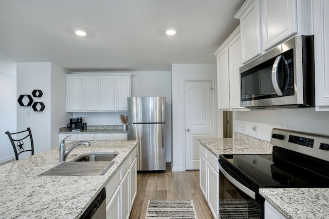 kitchen featuring white cabinets, light stone counters, sink, and stainless steel appliances