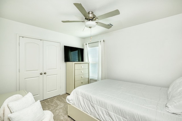 carpeted bedroom with ceiling fan and a closet