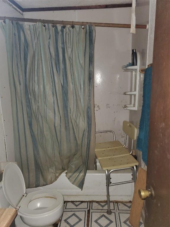 bathroom with toilet and shower / tub combo with curtain