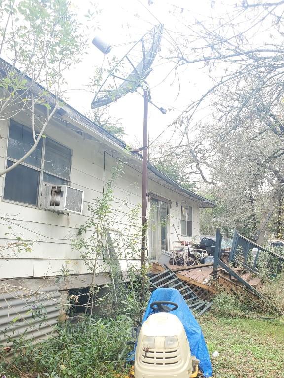 view of side of property featuring cooling unit and a deck