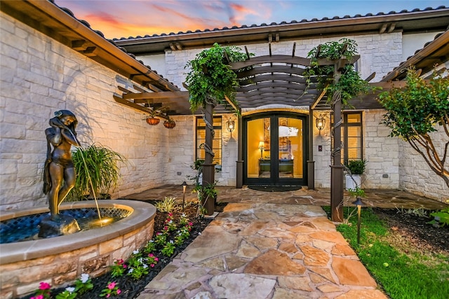 exterior entry at dusk featuring french doors