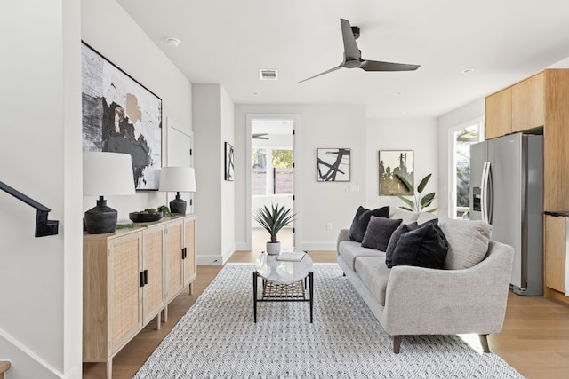 living room featuring ceiling fan, plenty of natural light, and light wood-type flooring