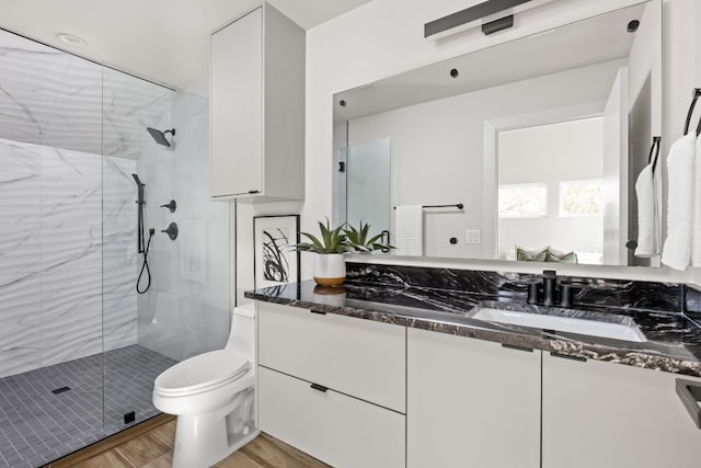 bathroom with vanity, wood-type flooring, toilet, and walk in shower