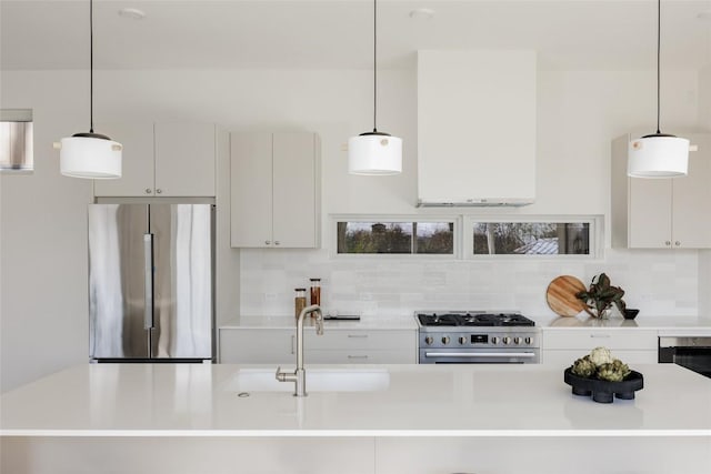 kitchen with pendant lighting, white cabinets, sink, decorative backsplash, and stainless steel appliances