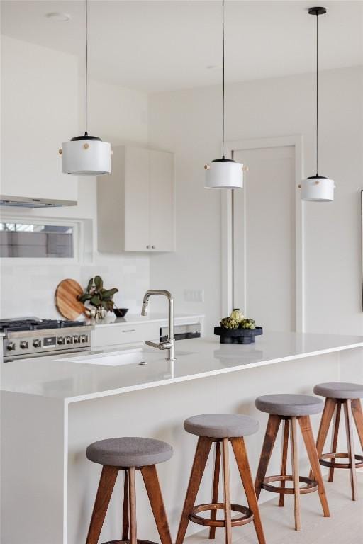 kitchen featuring white cabinets, decorative light fixtures, and a kitchen breakfast bar