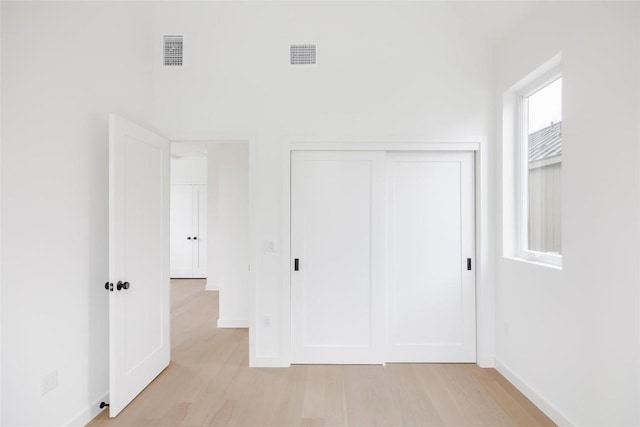 unfurnished bedroom featuring light hardwood / wood-style floors and a closet