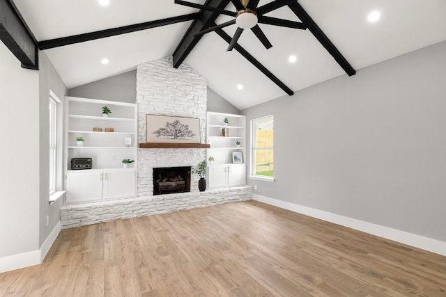 unfurnished living room with vaulted ceiling with beams, a fireplace, and light hardwood / wood-style floors