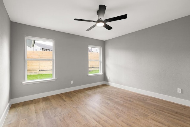 empty room featuring light hardwood / wood-style flooring, ceiling fan, and a healthy amount of sunlight