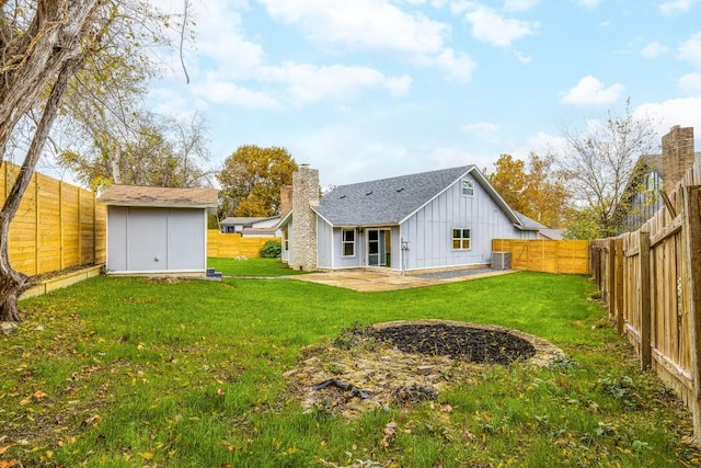 rear view of house featuring a yard, a patio, and a shed