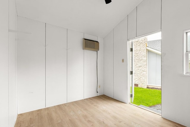 interior space with a wall mounted AC and light hardwood / wood-style floors