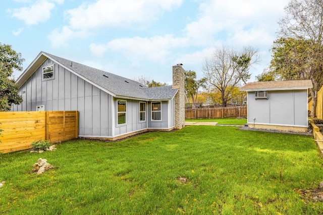 back of property featuring a shed, a yard, and a wall unit AC