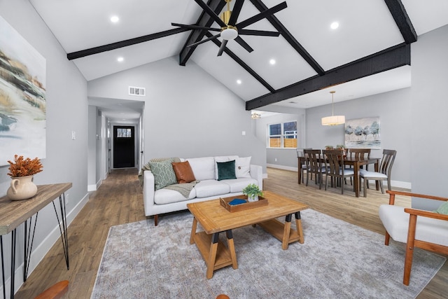 living area featuring visible vents, ceiling fan, wood finished floors, beamed ceiling, and high vaulted ceiling