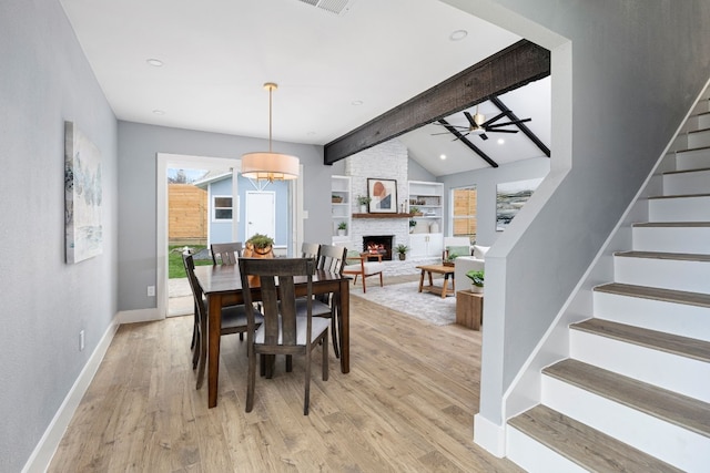 dining room featuring vaulted ceiling with beams, baseboards, stairs, built in features, and light wood-type flooring