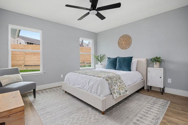 bedroom featuring wood finished floors, a ceiling fan, and baseboards