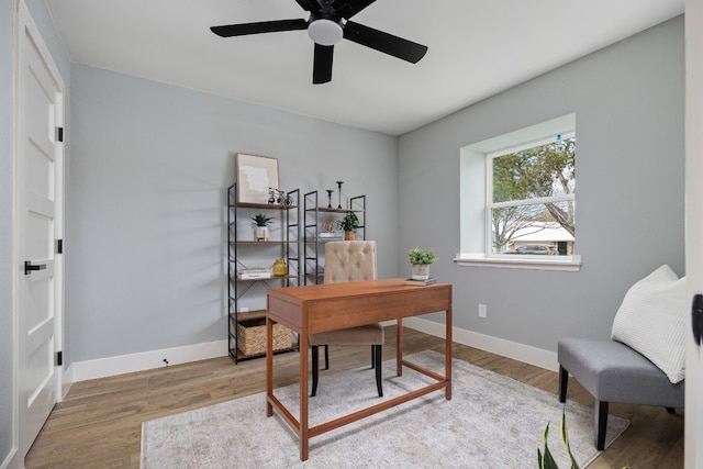 office space with light wood-style flooring, baseboards, and a ceiling fan