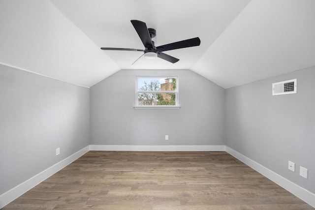 bonus room featuring visible vents, vaulted ceiling, baseboards, and wood finished floors