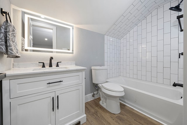 full bath featuring shower / bathtub combination, toilet, wood finished floors, vanity, and vaulted ceiling