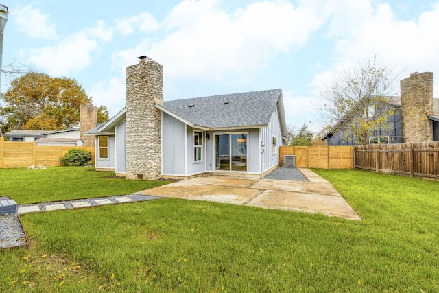 rear view of property with a yard, a fenced backyard, and a patio