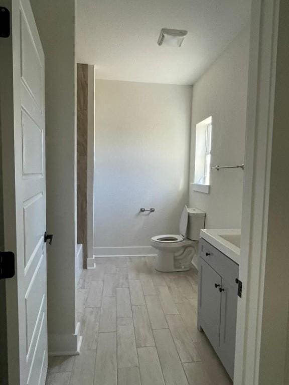 bathroom featuring vanity, hardwood / wood-style flooring, and toilet