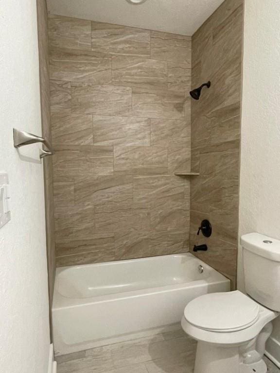 bathroom with tiled shower / bath and toilet